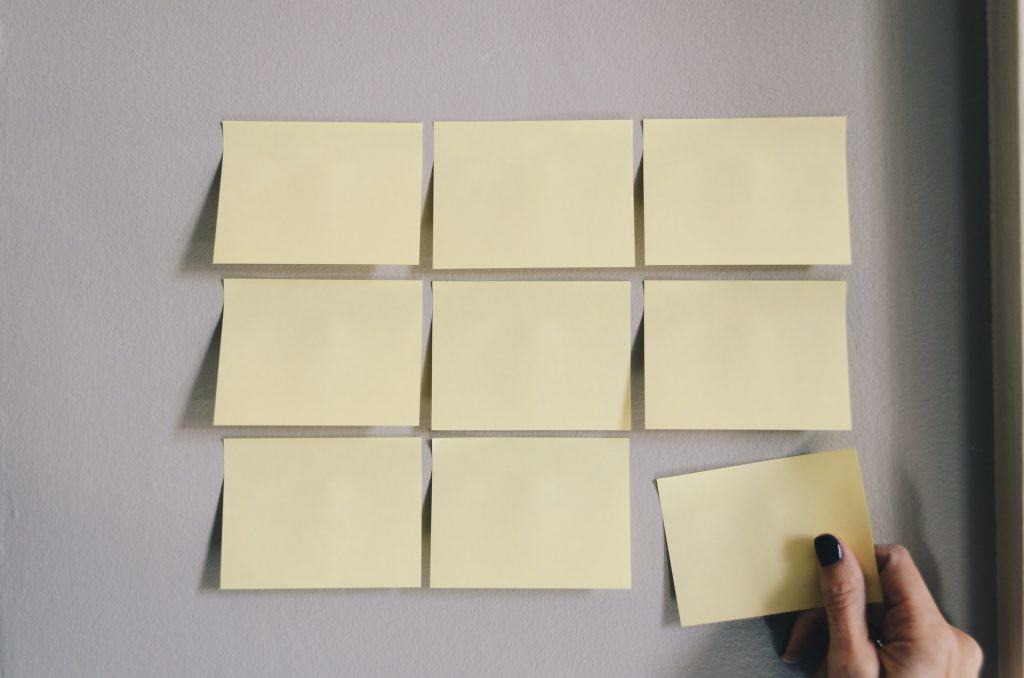 Post it notes on a wall are shown with one being taken off a wall. 75/25 Rule: Reminding vs. Teaching